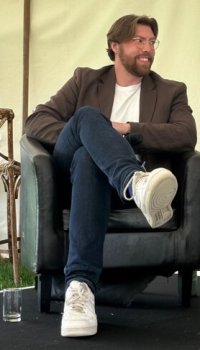 A photo of Jackson van Uden, the historian sitting.